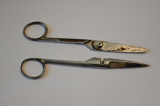 Rusty broken scissors on a plain surface