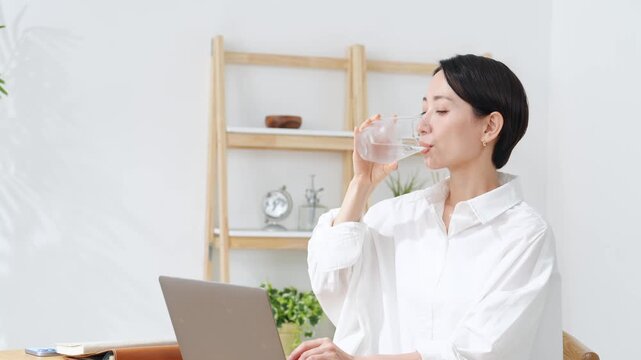 水を飲んでむせる女性。せき、咽せる、老化、誤嚥、誤飲、健康、ヘルスケア、のど、気道、気管、水分補給