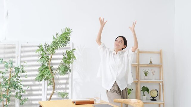 A middle-aged woman dancing in her room. Relaxed, smiling, happy, joyful, fun, energetic, dancing, satisfied, liberated, free, housewife.