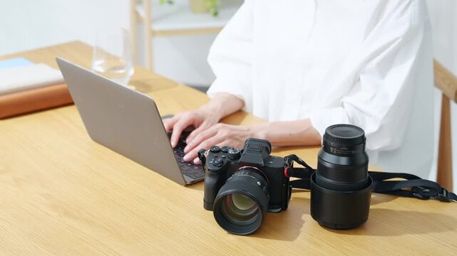 A woman using a camera and a laptop. Photography, editing, shooting, photographer, female photographer, developing, auction, listing.