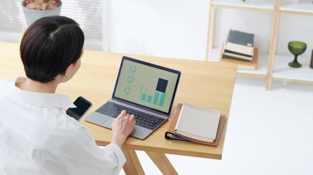 A woman using a laptop. Desk work, DX, work, freelance, working from home, office work, systems, working.