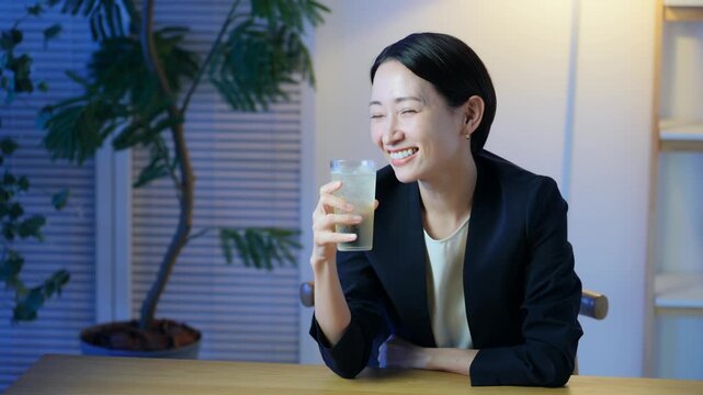 暗い部屋でお酒を飲む女性。ビール、ウイスキー、飲み会、居酒屋、バー、スナック、宅飲み