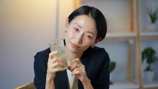 暗い部屋でお酒を飲む女性。ビール、ウイスキー、飲み会、居酒屋、バー、スナック、宅飲み