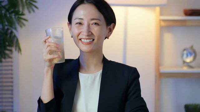 暗い部屋でお酒を飲む女性。ビール、ウイスキー、飲み会、居酒屋、バー、スナック、宅飲み