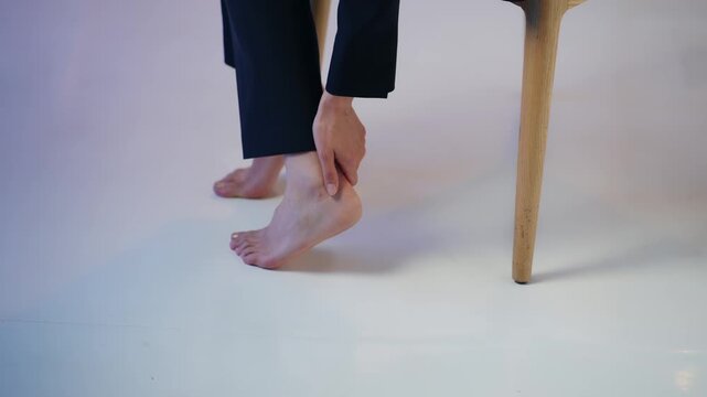 A woman stroking her feet. Heels, ankles, foot care, callus removal, fatigue, peeling, cream, dryness, moisturizing, blisters.