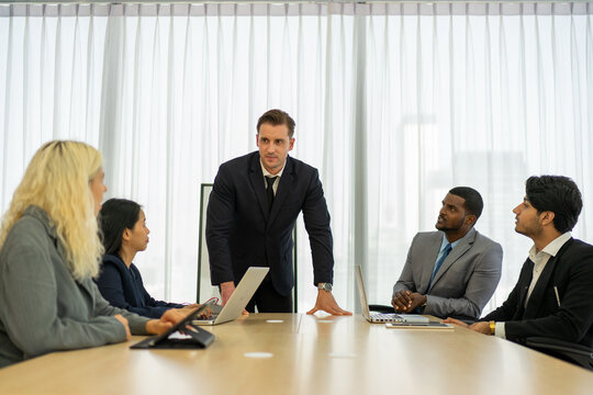 Business colleagues listening to manager at office conference table