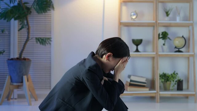 A middle-aged woman is depressed in a dark room. Worries, anxieties, worries, stress, depression, despair, mental health, regret, failure