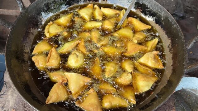 Indian samosa deep frying in hot oil 4k video footage