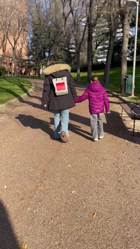 Madre e hija de la mano juntas vuelta al cole acompa&ntilde;ar mam&aacute; y ni&ntilde;a escolar a la escuela