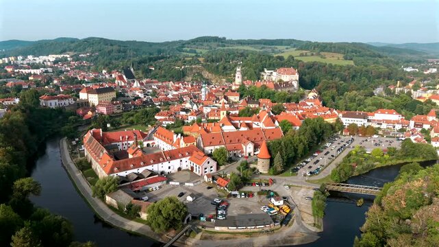 Morning golden-hour drone panorama of Česk&yacute; Krumlov encircled by the Vltava river, with the castle and old town, Czech Republic