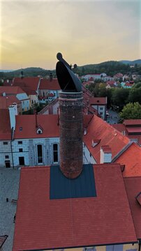 Vertical aerial drone orbiting closely around the old malthouse chimney of a historic brewery in Česk&yacute; Krumlov, Czech Republic