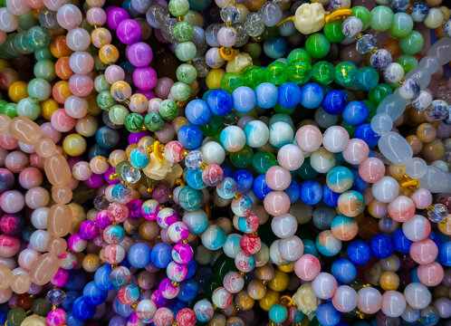 Colorful Beaded Bracelets Stacked Together. A Large Pile of Colorful Stone Bead colliere. Vibrant Handmade Gemstone Bracelets and Necklaces Background