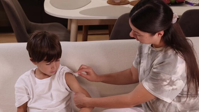 Adult sits beside a child before an injection