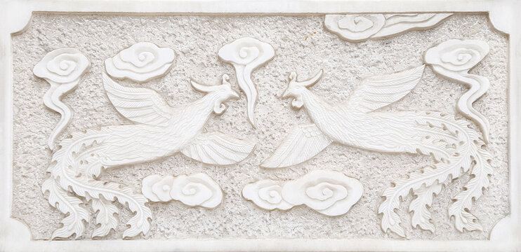 Traditional Chinese phoenix and dragon bas-relief sculpture on white stone wall