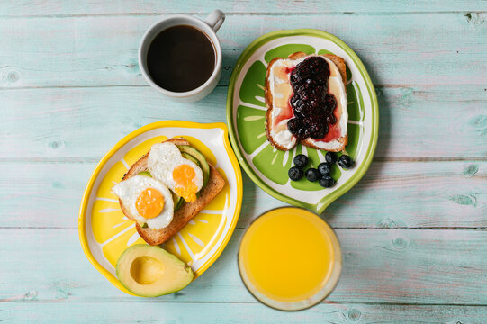 Healthy breakfast with avocado toast, eggs, and berry jam