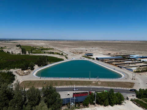 Large blue molten salt thermal storage pool in desert landscape