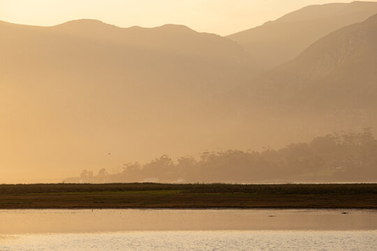 pastel sunset over placid lagoon and Klein Mountain reflection, Stanford, South Africa