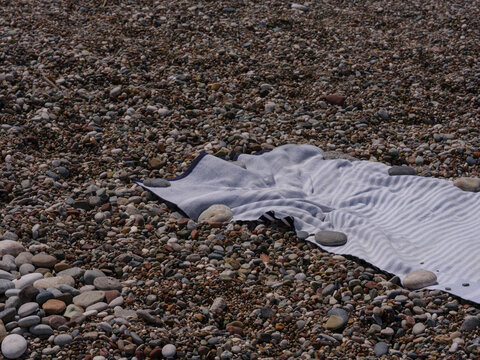 Beach towel spread on a pebble beach