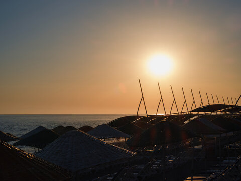 Sun loungers on a beach by the sea at sunset