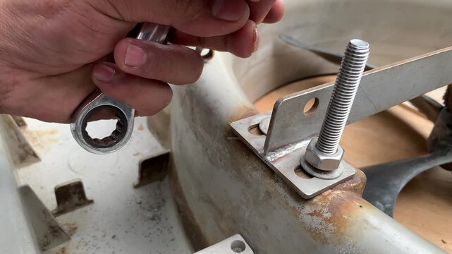 view of technician hand loosening a nut on a threaded rod