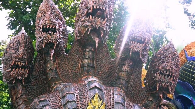 Sacred golden Buddha statues and colorful traditional giant guardian sculptures inside a historic Buddhist temple sanctuary.