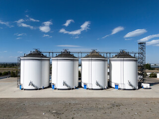 white cylindrical grain silos under blue sky © zhu difeng