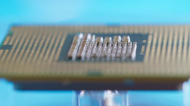 CPU computer microprocessor chip showing golden pins and capacitors on a blue background as a conceptual backdrop for artificial intelligence hardware semiconductor innovation cloud computing and info