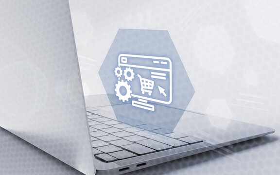 Una computadora port&aacute;til abierta muestra un icono digital de comercio electr&oacute;nico con engranajes, carrito de compras y pantalla web en un entorno tecnol&oacute;gico.