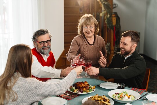 Family celebrating christmas dinner toasting together at home