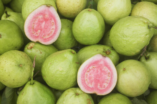 Many fresh pink guava fruits close up	