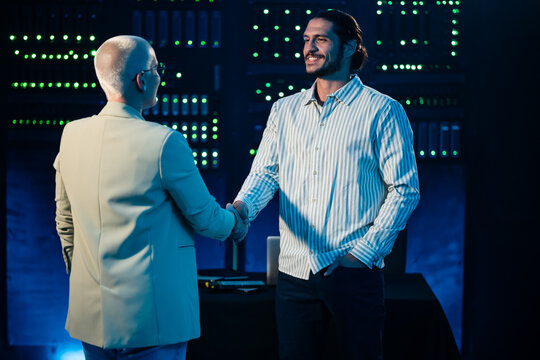 Professionals shaking hands confirming a technology business agreement