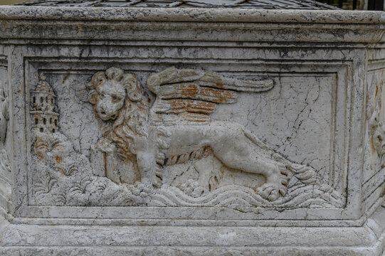 Venetian winged lion of St Mark carved on the stone well head on Vela placa square, Krk town, Krk island, Croatia