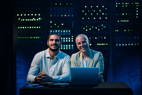 It professionals smiling in data center server room