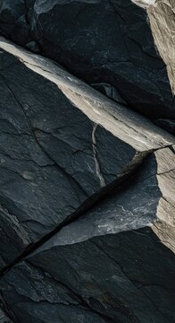 Close-up macro view of jagged gray natural rock surface featuring deep crevices and high contrast shadowing, illustrating extreme roughness ,jagged ,detailed ,grainy