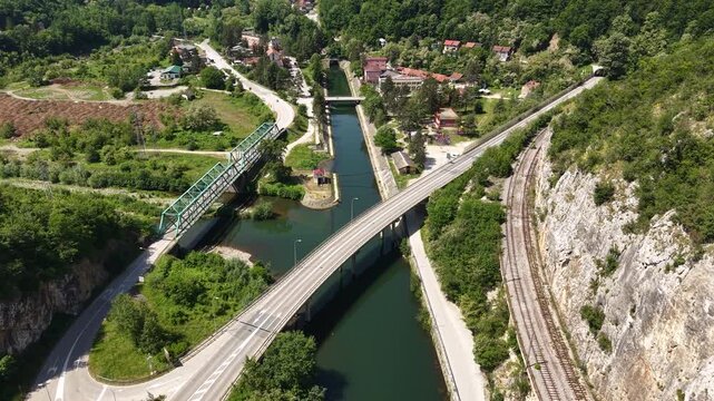 Revealing Drone Shot of Ovcar Banja, Serbia. Road Traffic, Railway and Buildings by West Morava River