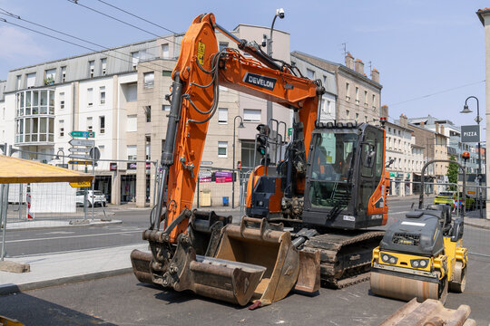 Nancy, France - July 25th 2026 : View on an orange crawler excavator Develon DX140LCR-7 on a construction site for work on the district heating network.
