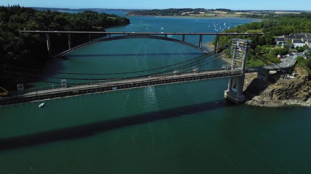 Aerial drone view of Pont Saint-Hubert crossing the Rance River in Brittany, France, with the surrounding green landscape and deep blue-green water visible from above.