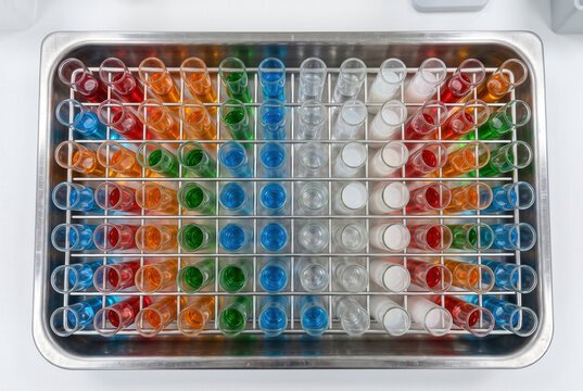 Test Tubes Filled with Colorful Liquids in a Metal Rack