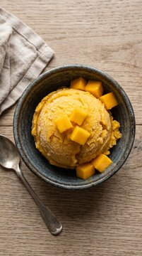 Golden mango sorbet served with fresh cubes tropical refreshing sweet indulgent fruity dessert