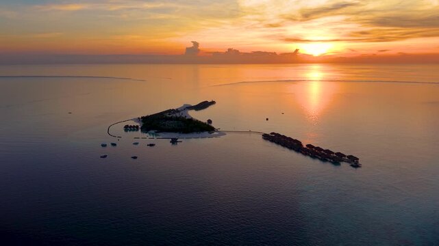 Aerial view of a small island in the Maldives, Indian Ocean, during a beautiful sunset with calm ocean