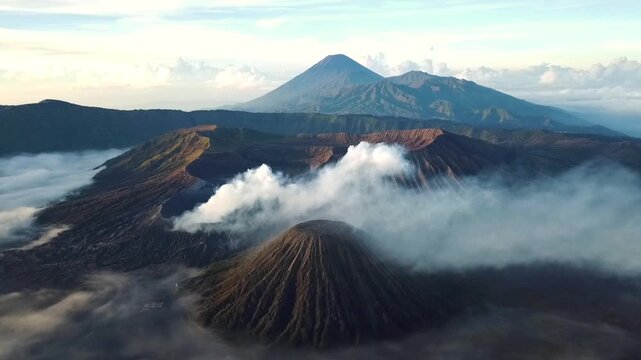 Aerial drone footage of Mount Bromo active volcano crater with rising smoke and majestic mountain landscape in East Java, Indonesia.