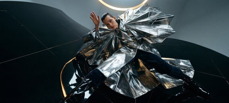 Avant Garde Christmas and New Year Couture Campaign with Male Model in Sculptural Silver Metallic Coat, Bird's Eye View, Futuristic Snowflake Silhouette and Luxury Editorial Setting
