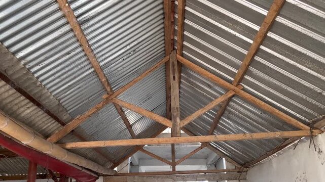 Low angle view of wooden roof structure with corrugated zinc sheets