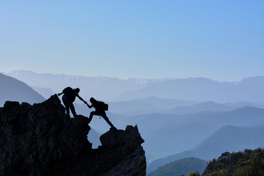 Climber Offering a Helping Hand, Leadership and Teamwork Concept