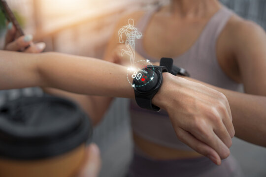 Woman checking smartwatch with holographic heart rate interface after workout
