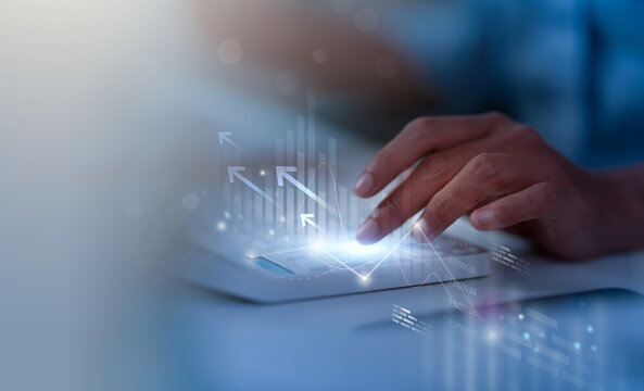 Cropped hand using calculator with financial growth chart overlay for business calculation