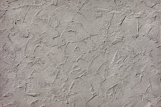 Neutral grey stucco wall texture background with rough trowel strokes for modern architectural design and interior decoration concept