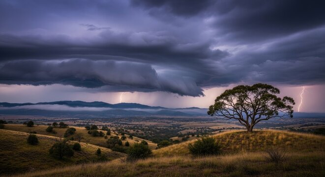 A dramatic landscape showcases a solitary tree silhouetted against a stormy sky. Lightning flashes illuminate the rolling hills and distant plains below.