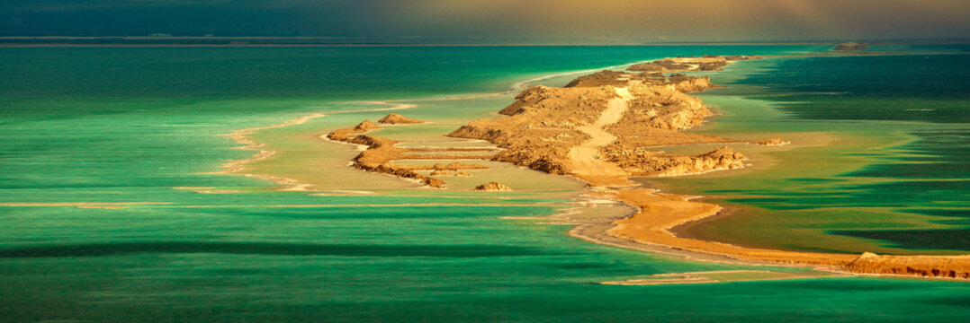 Seascape in the morning at dramatic light. A small island in the Dead Sea. View of Jordan from Israel