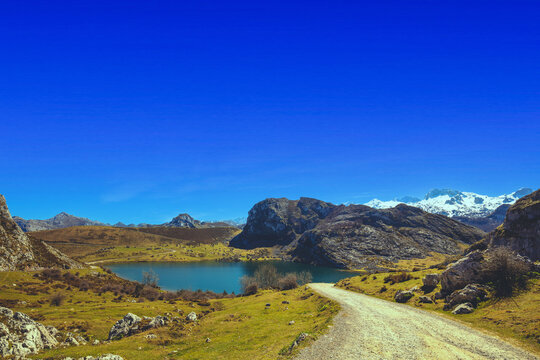 The dirt road to mountain lake. Beautiful mountain landscape. Peaks of Europe (Picos de Europa) National Park. A glacial Lake Enol. Asturias, Spain, Europe
